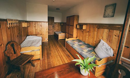 drewniany pokój z trzema łózkami